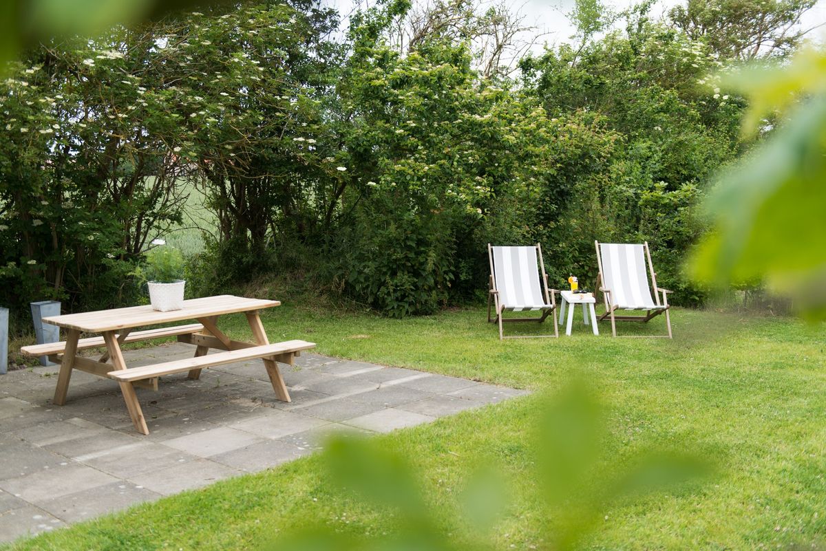 Jardín con mesa de picnic y tumbonas – Zeeuwshuisje casa de vacaciones, Koudekerke