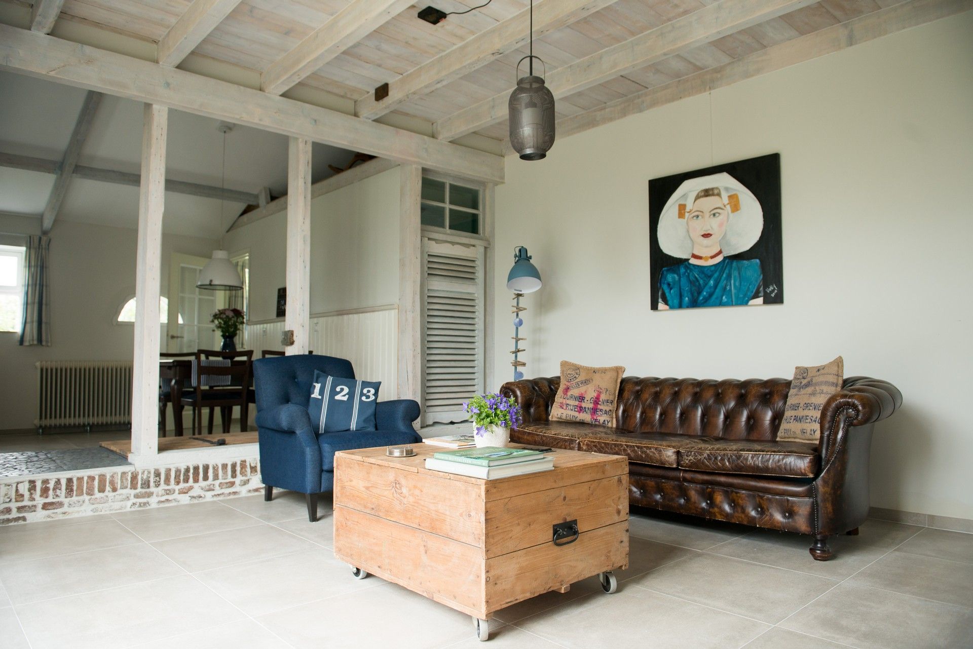 Light-filled living room with leather Chesterfield sofa and exposed wooden beams – Zeeuwshuisje, Koudekerke