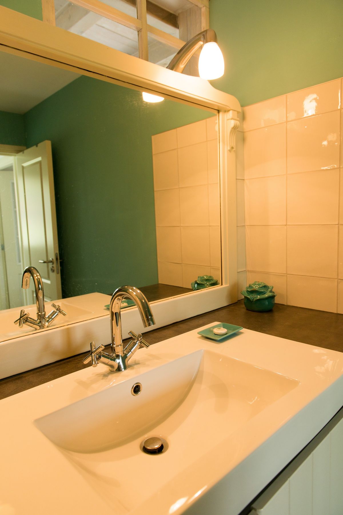 Mueble lavabo del baño con espejo y azulejos de terracota cálidos – Zeeuwshuisje casa de vacaciones, Koudekerke