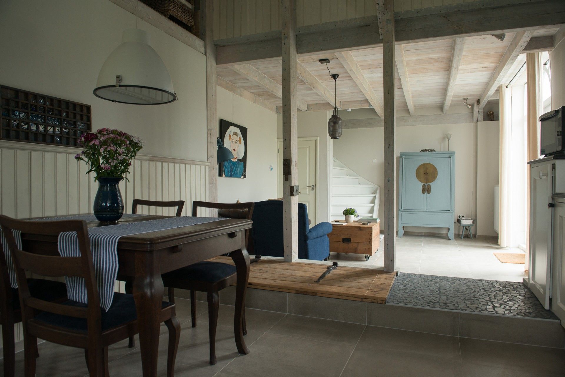Open-plan dining and living area with garden views and vintage blue cabinet – Zeeuwshuisje, Koudekerke