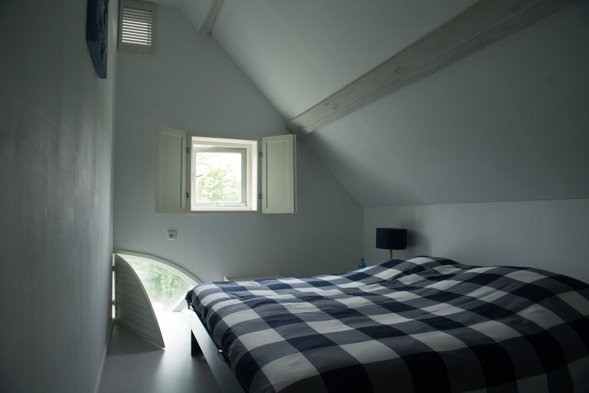 Habitación principal con cama doble y techo inclinado bajo el alero – Zeeuwshuisje casa de vacaciones, Koudekerke